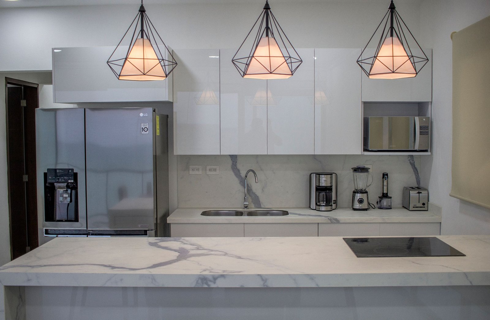 Sleek and contemporary kitchen featuring marble countertops and stylish lighting.